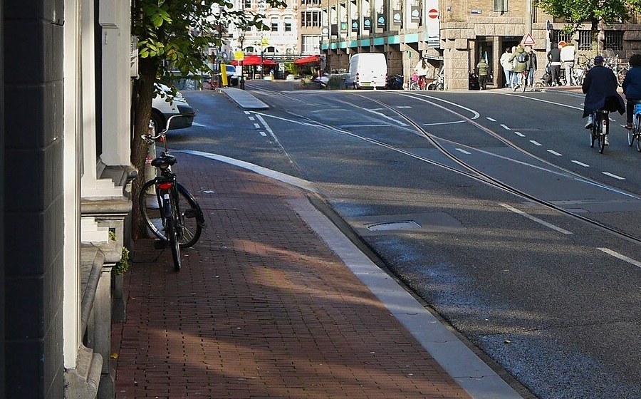 The same street after removal, with the curb line, tram rails and bricks continuing where the pedestrian stood